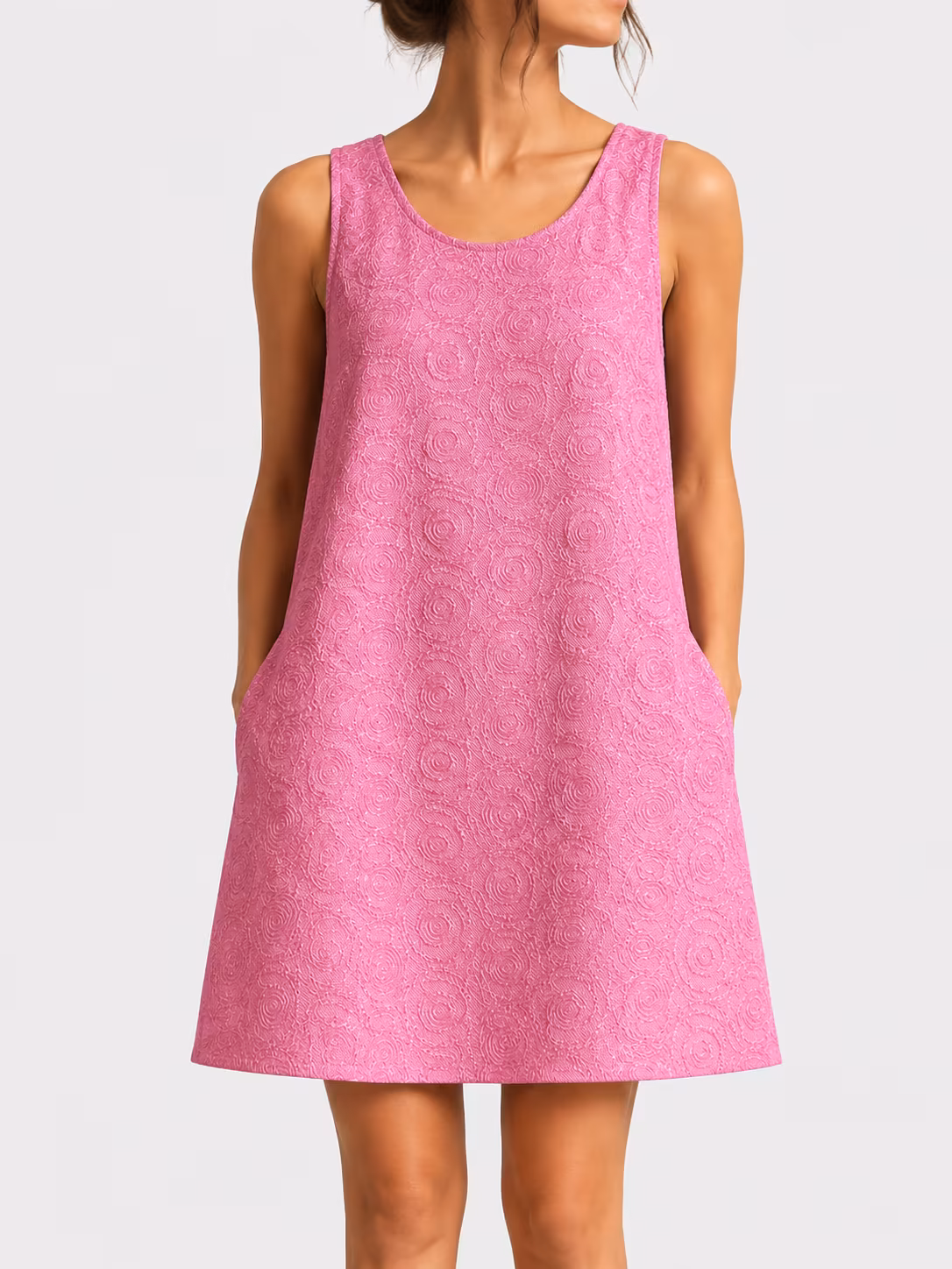 Robe trapèze rose sans manches réalisée dans un tissu brocart texturé à motifs de cercles concentriques et spirales. Coupe évasée au-dessus du genou avec encolure ronde et poches discrètes sur les côtés, présentée sur un mannequin de face sur fond clair.